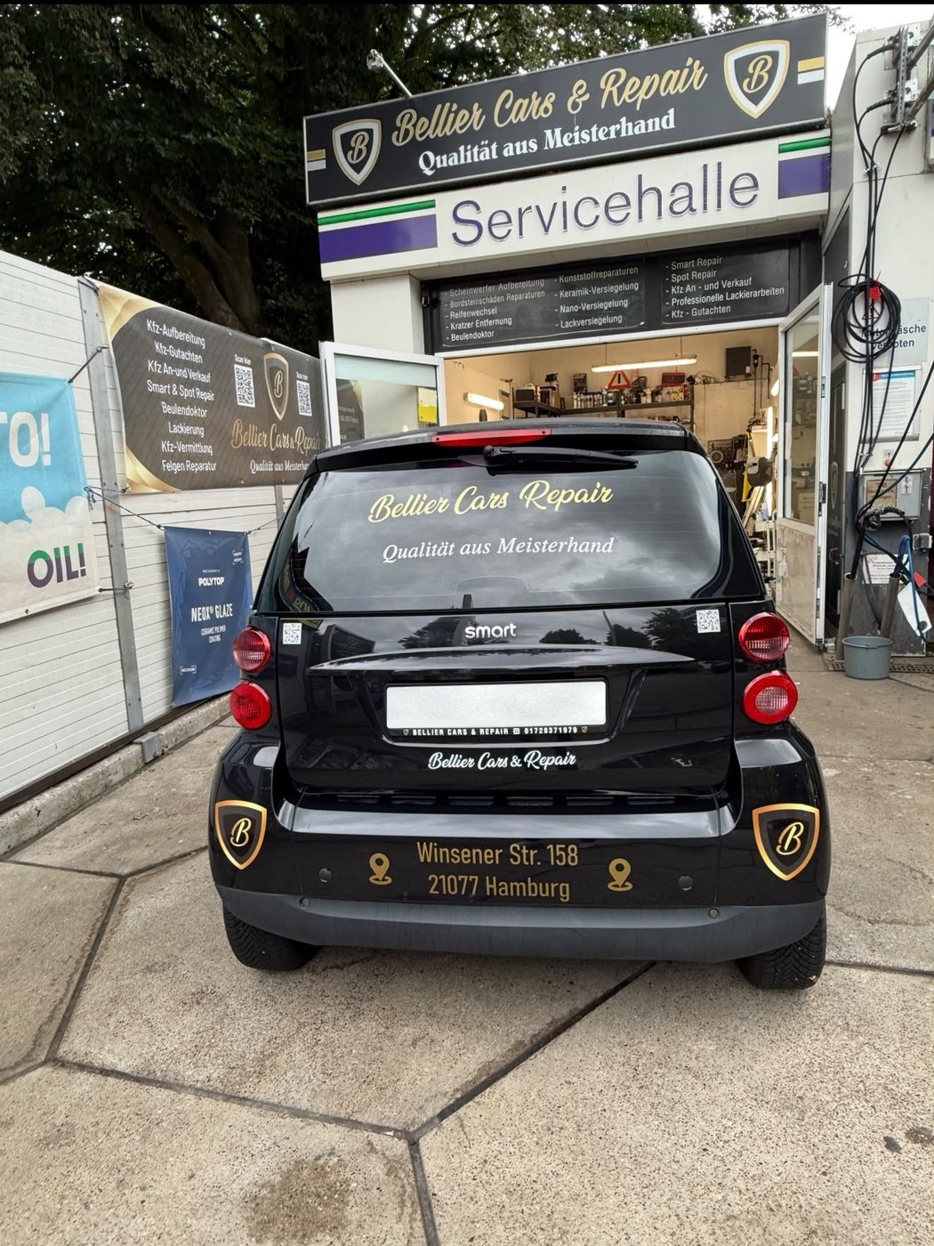 Schwarzer Firmenwagen von Bellier Cars & Repair vor der Servicehalle